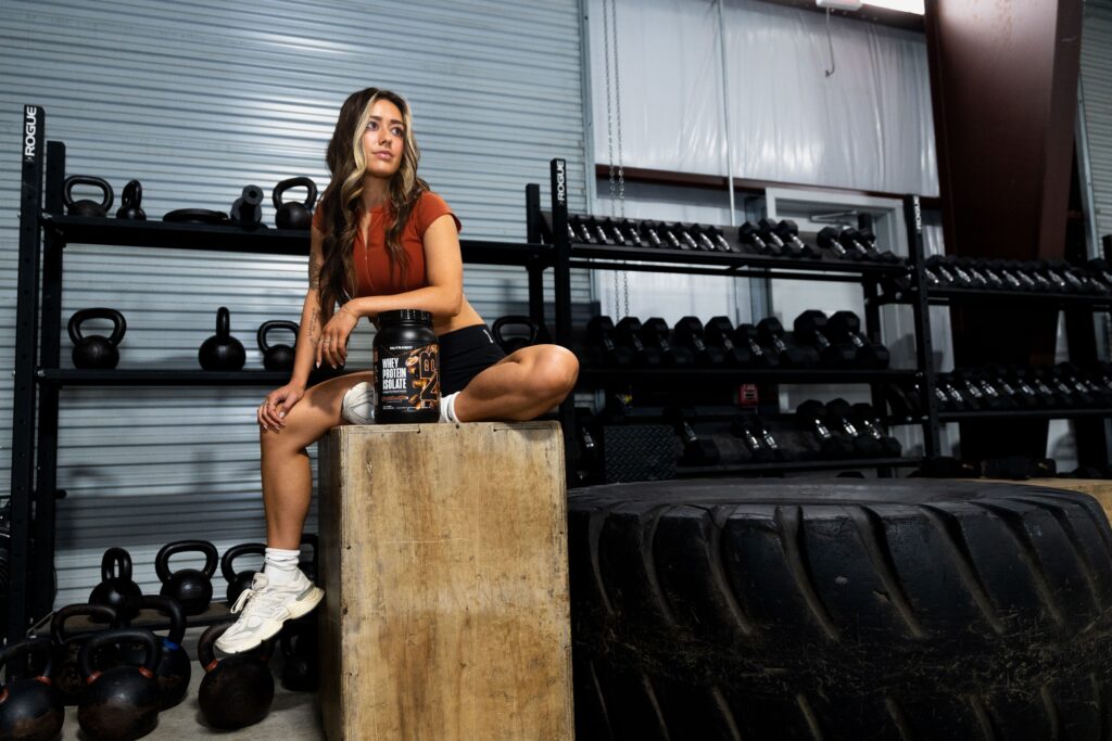 girl sitting on box with protein powder